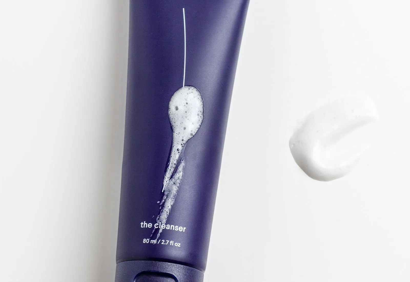 Purple tube labelled the cleanser with a smear of white foam beside it